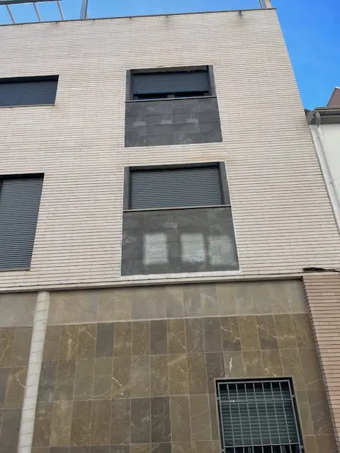 Fachada renovada de comunidad de vecinos en Granada con pintura y acabados modernos