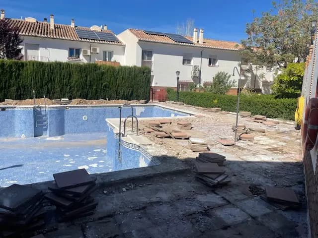 Reforma integral de piscina en Granada con coronación de piedra natural y acabados premium